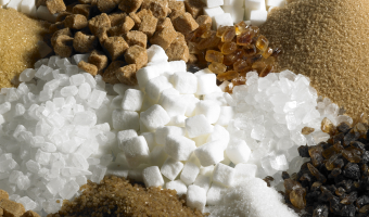 A variety of sugars are shown mixed together including brown sugar, cane sugar, marsh mellows and more.
