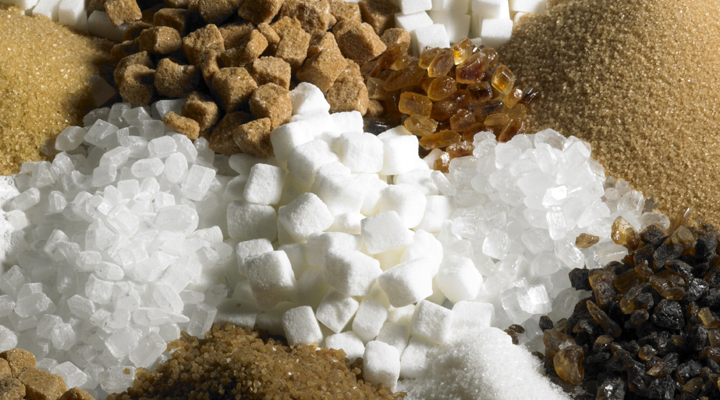 A variety of sugars are shown mixed together including brown sugar, cane sugar, marsh mellows and more.